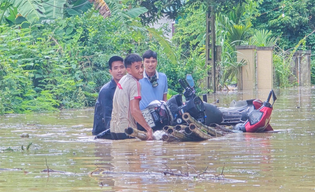 Người dân sống bên quốc lộ 7 đưa tài sản lên chỗ cao tránh trú, ngày 23/7. Ảnh: Hùng Lê
